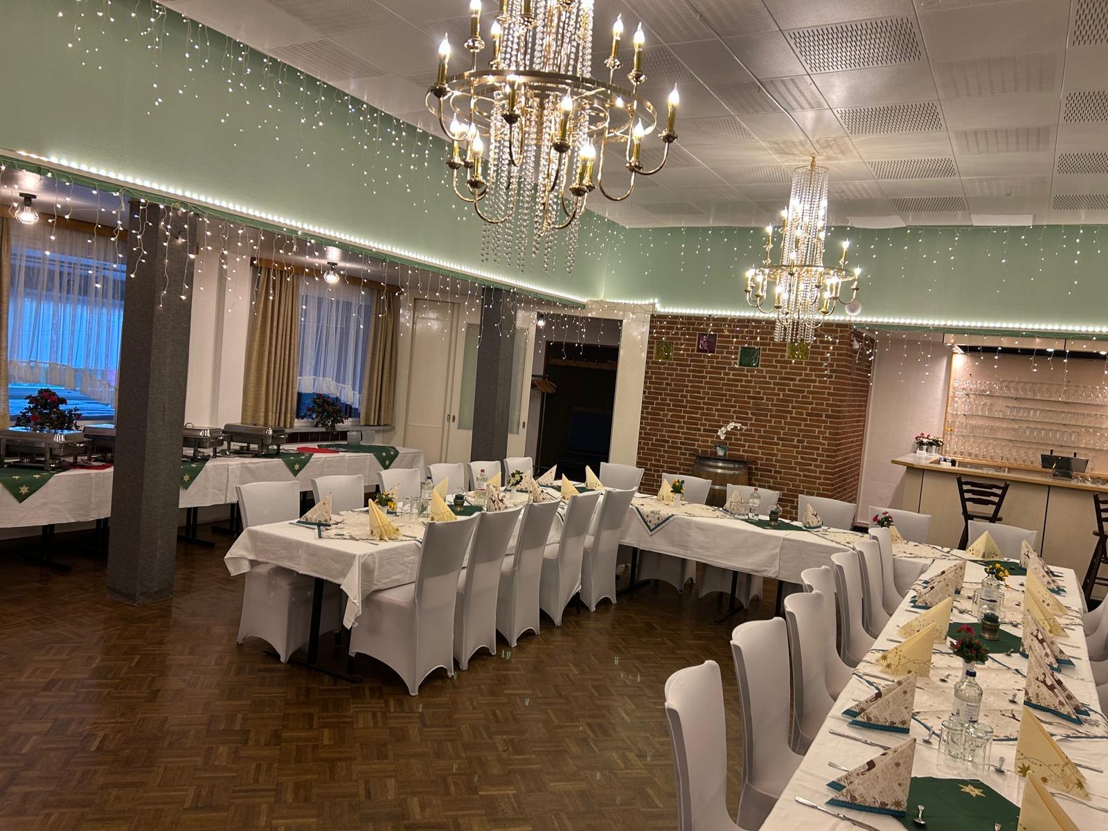 Saal mit Bühne, Tanzfläche und weihnachtlicher Dekoration